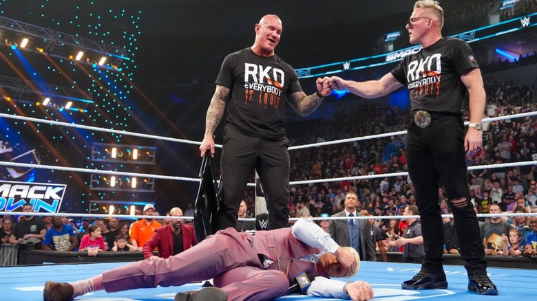 Pat McAfee and Randy Orton bump fists over a fallen Cody Rhodes during the segment where the former commentator was revealed to be helping Orton on 