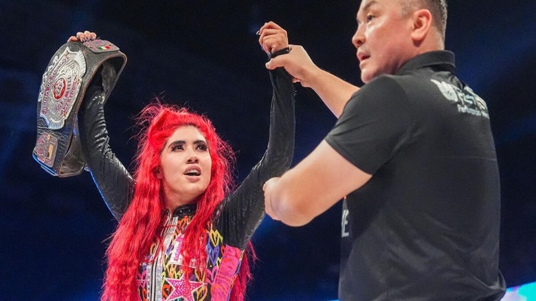 A referee holds up the arm of AAA Reina de Reinas Champion La Catalina following her victory over Roxanne Perez at WWE x AAA Worlds Collide 2026.