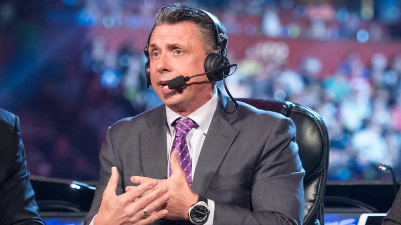 Michael Cole offers commentary while wearing a headset.