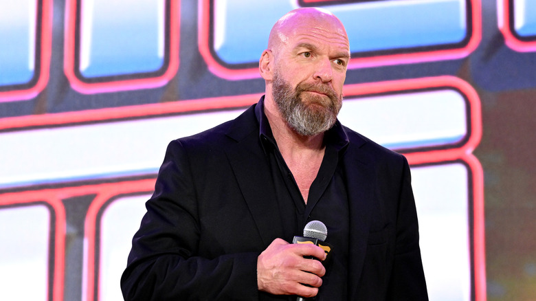 Paul Levesque holding a microphone