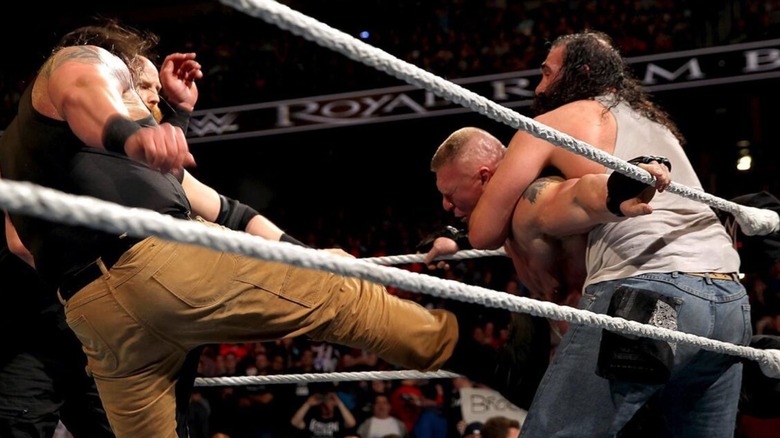 Luke Harper holds Brock Lesnar in the corner as Braun Strowman and Erick Rowan beat him down during the 2016 Royal Rumble.
