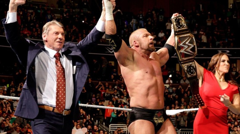 Vince and Stephanie McMahon hold up the hands of Triple H, the winner of the Royal Rumble and the new WWE Champion, in the middle of the ring after the event in 2016.