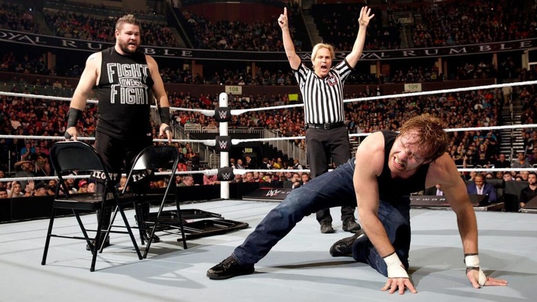 Kevin Owens stands over a pair of chairs set up in the ring, and a fallen Dean Ambrose on the canvas, as a referee counts to 10 during their Last Man Standing Match in 2016.