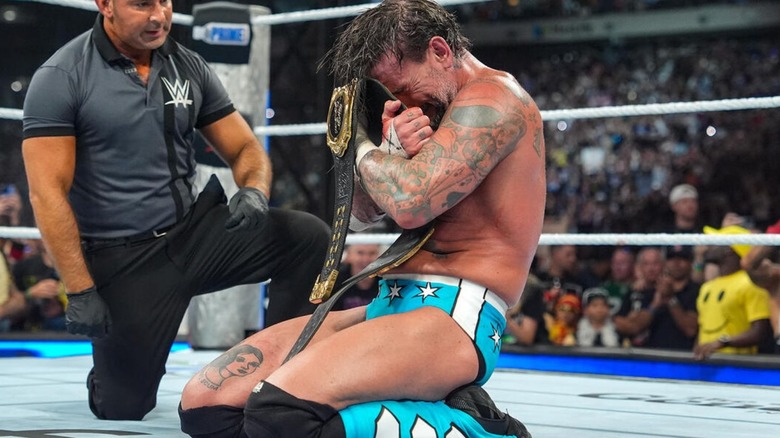 CM Punk clutches the World Heavyweight Championship after his victory at SummerSlam.