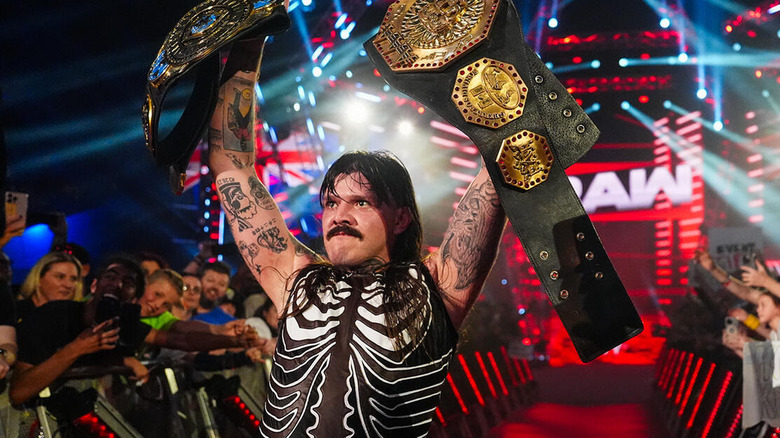 Dominik Mysterio holds up his two title belts on "WWE Raw"