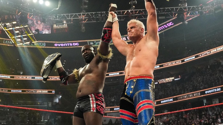 Undisputed WWE Champion Cody Rhodes holds up the hand of NXT Champion Oba Femi in the ring after their match at Saturday Night's Main Event.