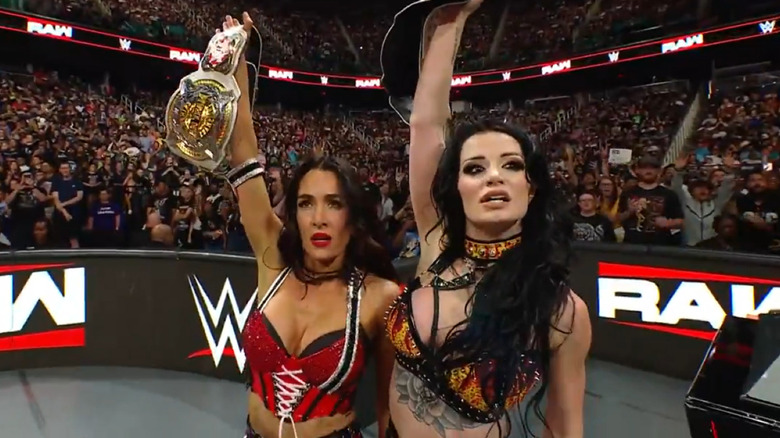 Brie Bella and Paige hold the Women's Tag titles aloft