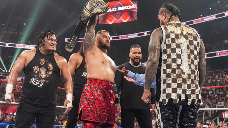 Solo Sikoa stands alongside his M.F.Ts as he raises the United States Championship above his head