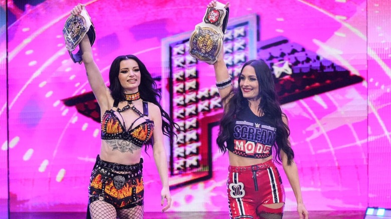 WWE Women's Tag Team Champions Paige and Brie Bella head down to the ring, titles in hand, for a match on 
