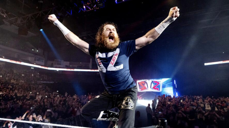 Zayn at an event raising his hands