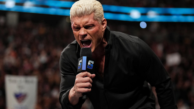 An injured Cody Rhodes spits into the microphone.