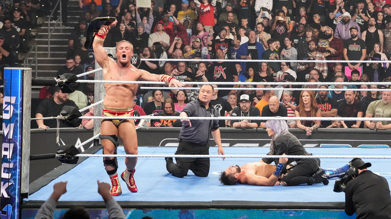 Ilja Dragunov raises the men's US title as Candice LeRae checks on Johnny Gargano on "WWE SmackDown"