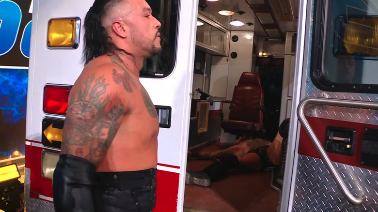 Damian Priest stands in front of an ambulance containing Aleister Black on "WWE SmackDown"