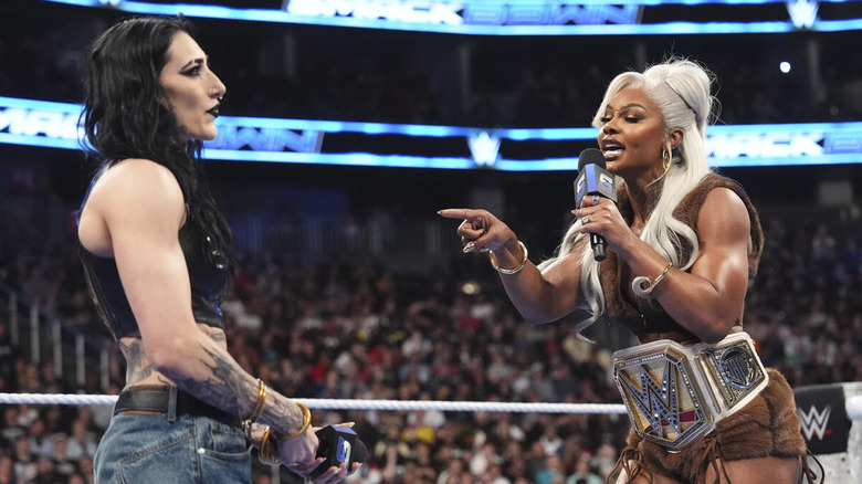 Jade Cargill speaking to Rhea Ripley on a microphone