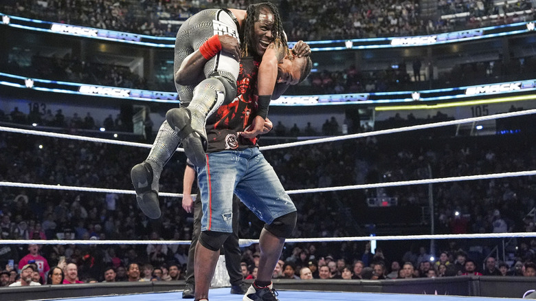 R-Truth with Carmelo Hayes in a fireman's carry on "WWE SmackDown"