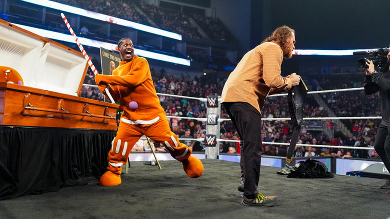 Lil Yachty in a gingerbread man costume winds up to hit Sami Zayn from behind with a candy cane on "WWE SmackDown"