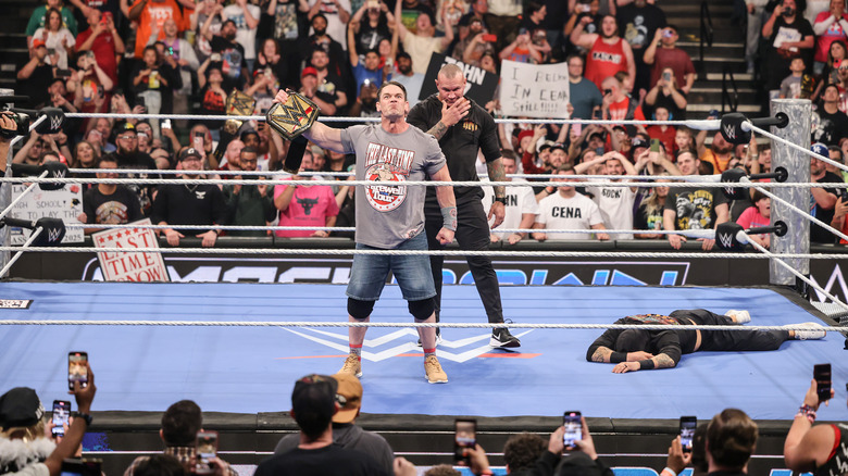 Orton standing behind Cena
