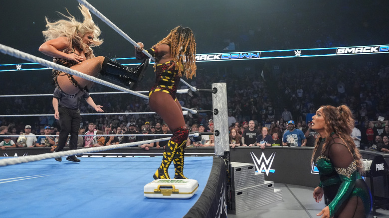 Tiffany Stratton dropkicks Naomi on the apron while Nia Jax looks on from ringside on "WWE SmackDown"