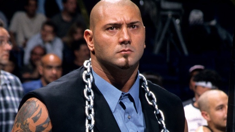 Batista wearing a suit with cut-off sleeves and a chain around his neck