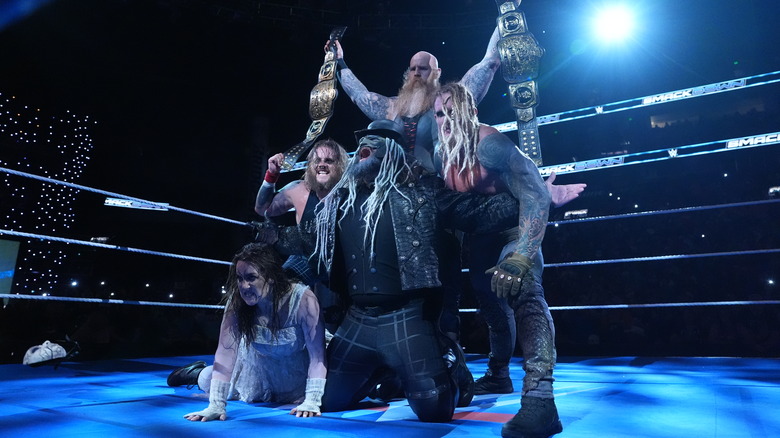 The Wyatt Sicks pose while holding up the WWE Tag Team Championship