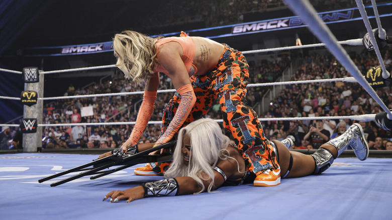 Charlotte Flair wraps a chair around the arm of Jade Cargill on "WWE SmackDown"