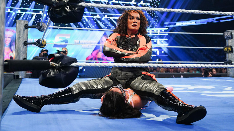 Nia Jax sitting on Chelsea Green with her arms crossed on "WWE SmackDown"