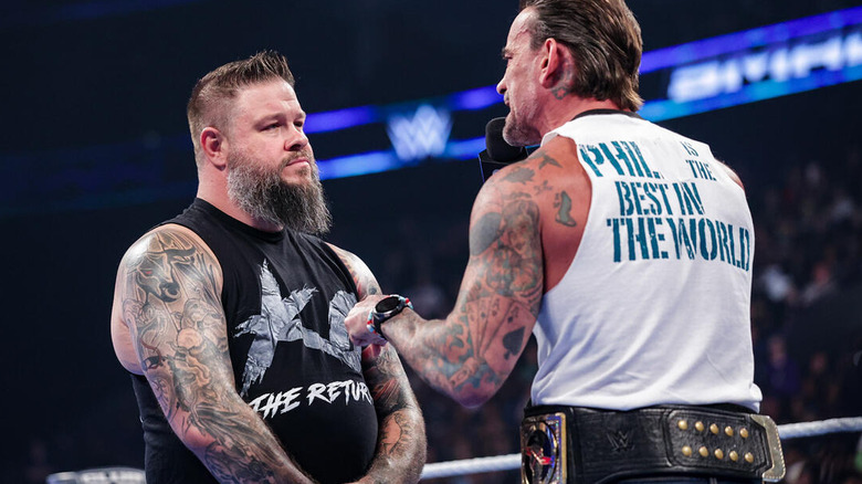 CM Punk speaking to Kevin Owens on the microphone on "WWE SmackDown"