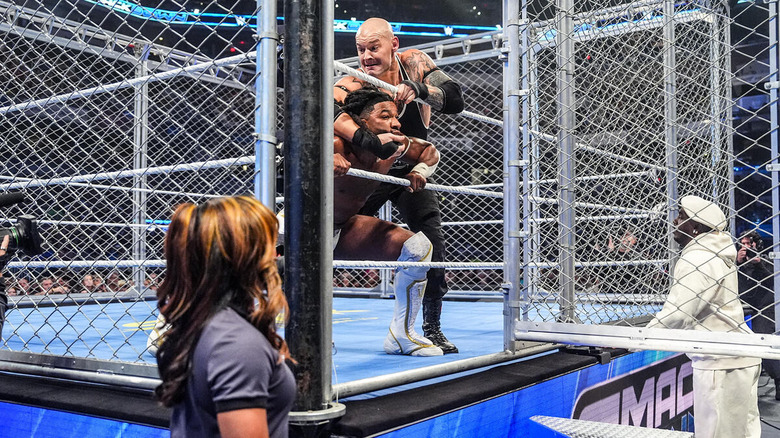 Baron Corbin wrestles with Trick Williams near the door of the steel cage while Lil Yachty watches on "WWE SmackDown"