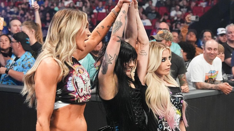 Tatum Paxley holds up the hands of Charlotte Flair and Alexa Bliss at ringside, after scoring a singles victory over Michin, on the August 28, 2026 edition of "WWE SmackDown."