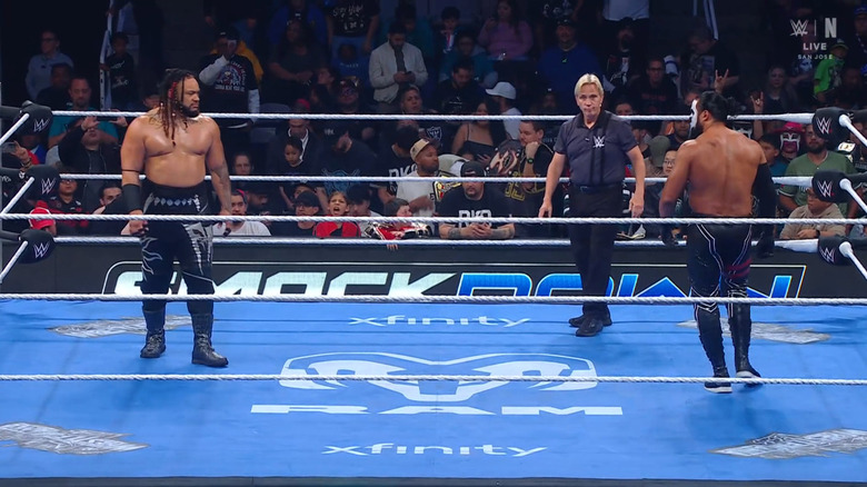 Fatu and Tama staring down one another in the ring