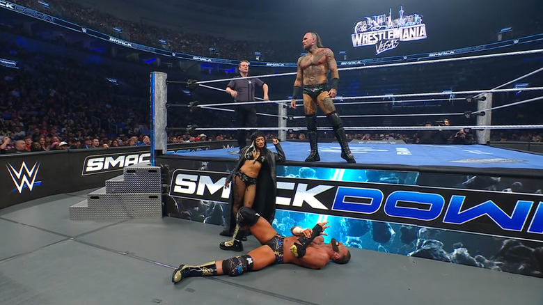 Black and Zelina standing over Cardona on the outside