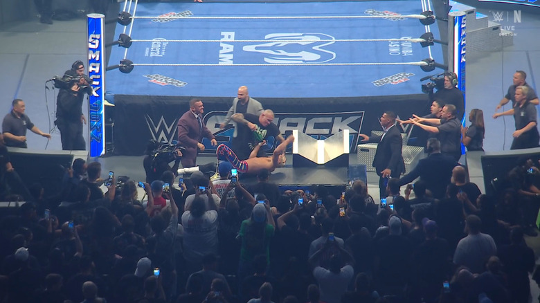 Orton raining down right hands on Rhodes on top of the announce desk as officials surround them
