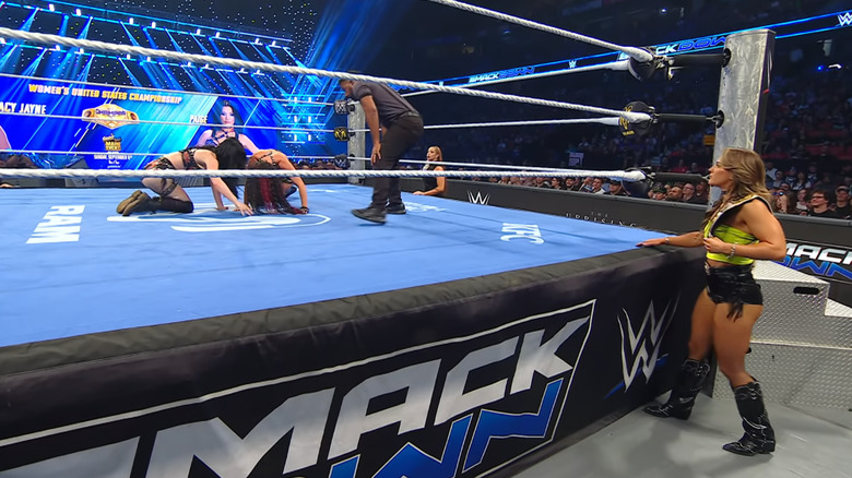 Henley watching from the outside as Jayne and Paige are inside the ring