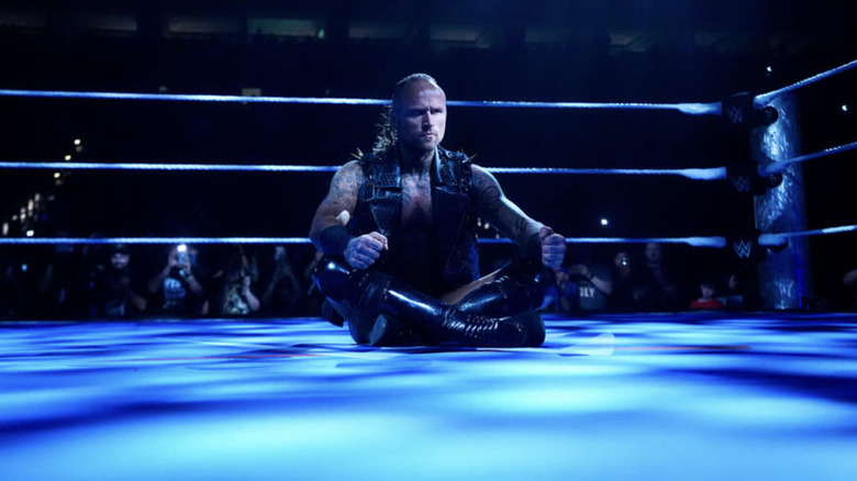 Black sitting cross-legged in the ring