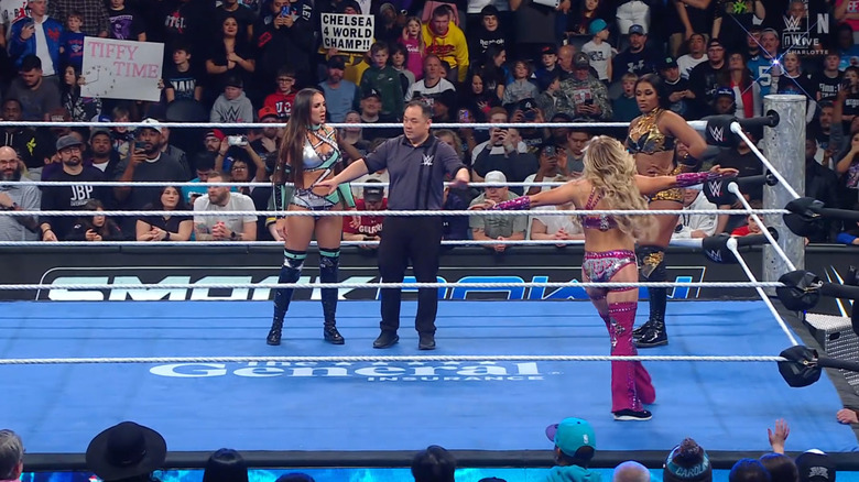 All three women staring each other down in the ring