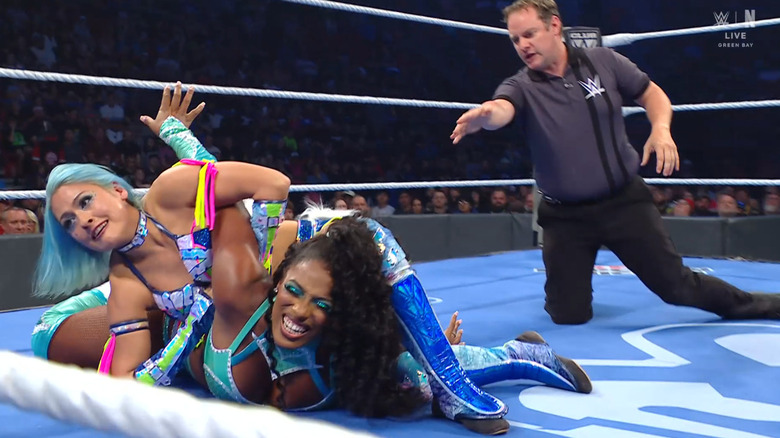 Giulia wearing down Legend with a submission hold