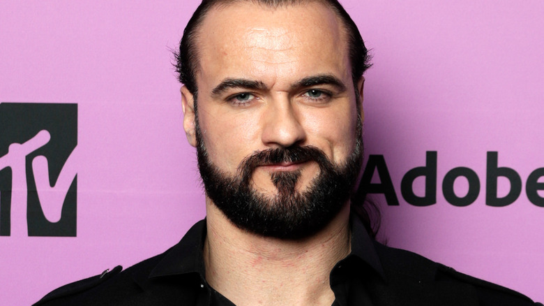 Drew McIntyre smiles at a press event 