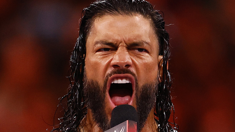 Roman Reigns shouting into microphone