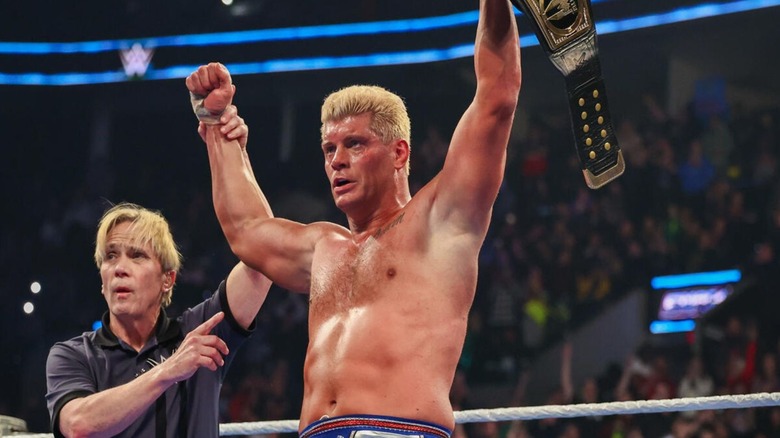 Referee Charles Robinson holds up the hand of Cody Rhodes after his victory over Drew McIntyre for the Undisputed WWE Championship on 