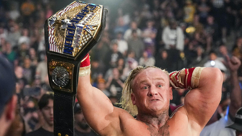 Ilja Dragunov holding his title in the air