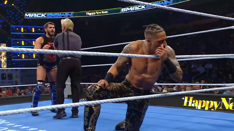 Gargano distracting the referee as Hayes looks at LeRae on the outside