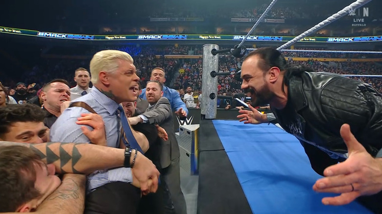 Rhodes being held back as McIntyre eggs him on