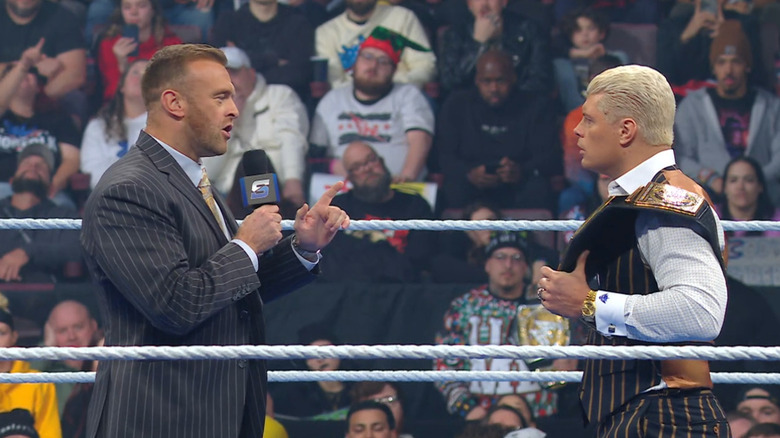 Aldis and Rhodes speaking with one another in the ring