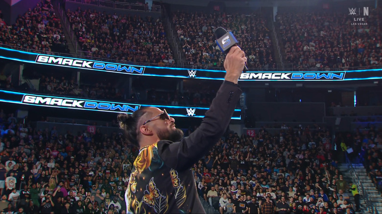 Rollins holding up a microphone