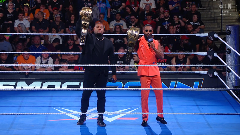 The Profits holding up the WWE Tag Team Championship belts