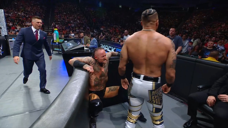 The Miz watching as Hayes beats down Black in the timekeeper's area