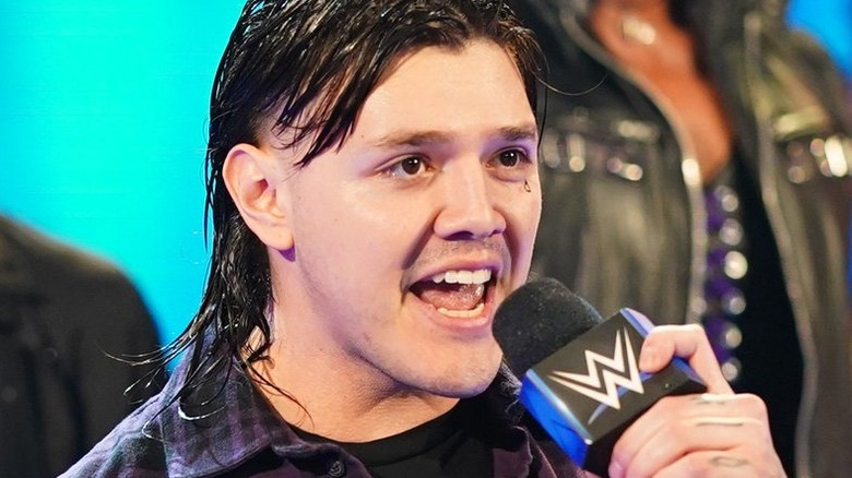 Dominik Mysterio talks into a microphone