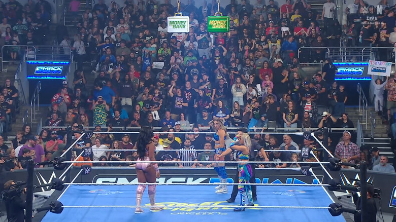 All three women inside the ring with the Money In The Bank briefcases handing above them