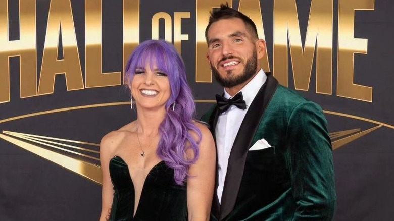Johnny Gargano and wife Candice LeRae smile and pose for the camera on the red carpet at the WWE Hall of Fame ceremony.