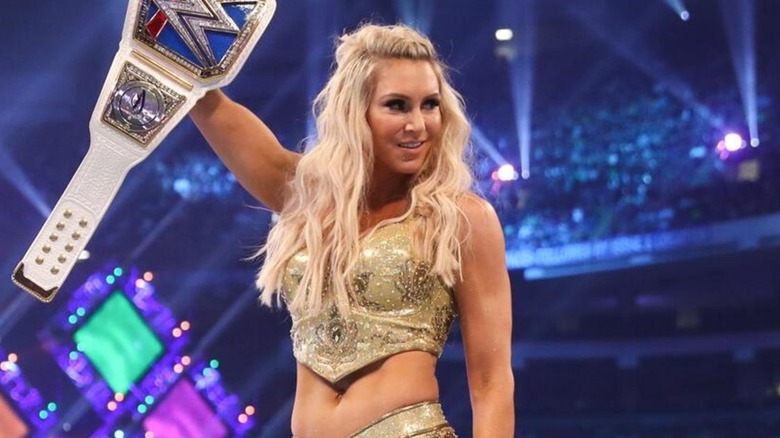 Charlotte Flair holding the SmackDown Women's Championship above her head at WrestleMania 34.